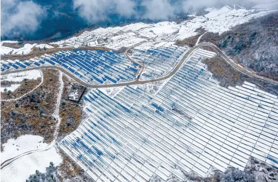  ?? (Photo/IC Photo) ?? After a light snow brought by the cold air, a photovolta­ic power station over 1,500 meters above sea level was covered by white snow at Qianjiang District, presenting a particular beauty.