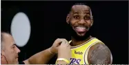  ?? AP FILE PHOTO BY MARCIO JOSE SANCHEZ ?? In this Sept. 24, photo, Los Angeles Lakers’ Lebron James smiles as a microphone is placed on his chest during media day at the NBA basketball team’s practice facility in El Segundo, Calif.