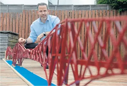  ?? Picture: SWNS. ?? Michael Dineen with the 15ft-long model of the bridge.