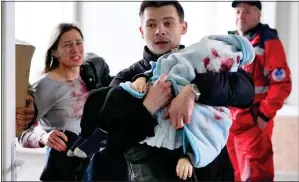  ?? ?? DESPERATE: Marina Yatsko and Fedor rush into the hospital, carrying their injured son