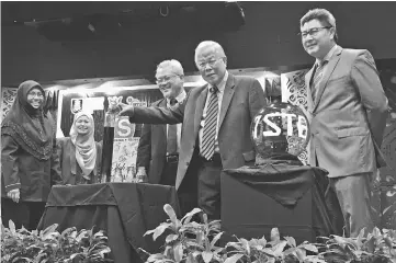  ??  ?? Manyin (second right) completes a chemistry experiment as part of the launch gimmick for UiTM Sarawak’s STEM Fair 2017 yesterday.