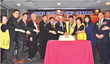  ??  ?? Edmond (fourth from right) together with Tiong (fifth from right), Kevin (second from left) and others jointly cutting the anniversar­y cake of Lions Club of Sibu Central.