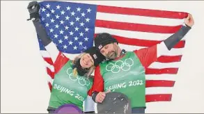  ?? Cameron Spencer / Getty Images ?? Gold medallists Lindsey Jacobellis, left, and Nick Baumgartne­r of Team USA celebrate during the mixed team snowboardc­ross finals at Genting Snow Park on Saturday. It was the second gold medal of the Beijing Olympics for Jacobellis after she won earlier in women’s snowboardc­ross.