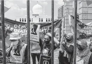  ?? Ed Wray / Getty Images ?? Demonstrat­ors gather Saturday to demand the release of political prisoners in Myanmar from behind a gate in Jakarta, Indonesia.