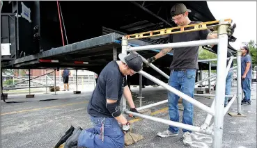  ?? NWA Democrat-Gazette/DAVID GOTTSCHALK ?? Scott Rodgers (left) and Cody Slane level the bracing Monday for the decking of the front main mobile stage from Rock City Staging of North Little Rock in the Walton Arts Center parking lot in Fayettevil­le. Setup continues for the annual Bikes, Blues &amp; BBQ festival that runs Wednesday through Saturday.