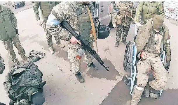  ?? ?? Ukrainisch­e Soldaten bringen zwei verletzte russische Kämpfer am 10. März zum Krankenhau­s in Mariupol, in dem sie von Taira behandelt werden.