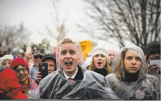  ?? Gabrielle Lurie / The Chronicle ?? Rain doesn’t seem to dampen the spirits of a crowd of President Trump’s supporters as they cheer the new commander in chief during his inaugurati­on speech on the Capitol steps.