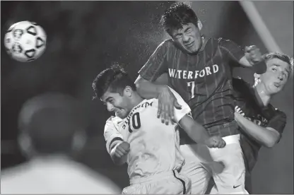  ?? TIM MARTIN/THE DAY ?? Jason Kilcoyne of Stonington (10) attempts to deflect the ball into the Waterford goal but is tied up by Waterford’s Walter Tineo (7) and Brent Rutchick, right, during the second half of Tuesday’s ECC Division II boys’ soccer game at Stonington.