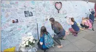  ?? AP PHOTO ?? People write in a wall as a tribute to Grenfell Tower’s residents at Latymer community centre in London Thursday.