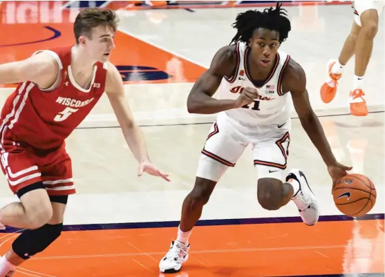  ?? HOLLY HART/AP ?? Ayo Dosunmu, driving past Wisconsin’s Tyler Wahl, notched Illinois’ first triple-double in 20 years Saturday. He had 21 points, 12 rebounds and 12 assists.