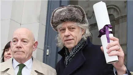 ??  ?? Irish musician Bob Geldof, right, holds aloft his Freedom of the City of Dublin scroll as he prepares to return it at Dublin City Hall, in Dublin, on Monday. (AFP)