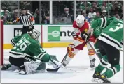  ?? TONY GUTIERREZ — THE ASSOCIATED PRESS ?? Dallas goaltender Jake Oettinger (29) knocks the puck away from Calgary’s Dillon Dube during Monday’s game.