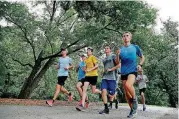  ?? THE OKLAHOMAN] BY SARAH PHIPPS, ?? Guthrie cross country coach James Strahorn, far left, runs with his team at Mineral Wells Park.[PHOTO