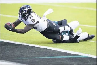  ?? DERIK HAMILTON — THE ASSOCIATED PRESS ?? Baltimore Ravens’ Gus Edwards (35) scores a touchdown in the first quarter despite the effort of Eagles linebacker Shaun Bradley. The Ravens jumped out to a 17-0 lead but had to hold on for a 30-28 victory Sunday at Lincoln Financial Field.