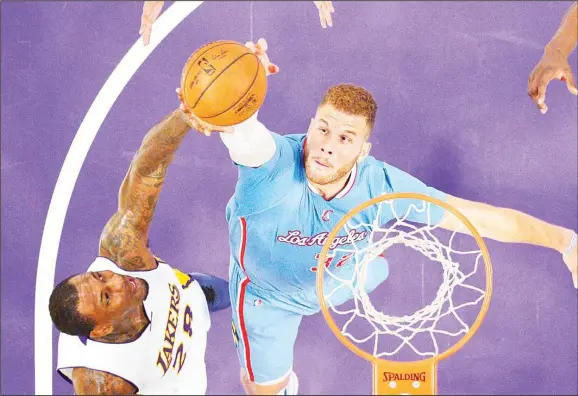  ??  ?? Los Angeles Lakers forward Tarik Black (left), and Los Angeles Clippers forward Blake Griffin reach for a rebound during the first half of an NBA basketball game, on April 5, in Los Angeles. (AP)