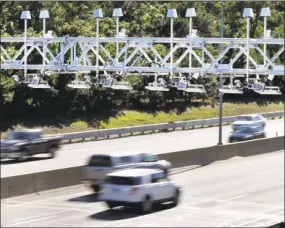  ?? AP file photo ?? In this Aug. 22, 2016 file photo, cars pass under toll sensor gantries hanging over the Massachuse­tts Turnpike in Newton, Mass.