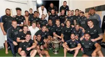  ?? PHOTOSPORT ?? The All Blacks celebrate with the Bledisloe Cup in the dressing room after last night’s game.