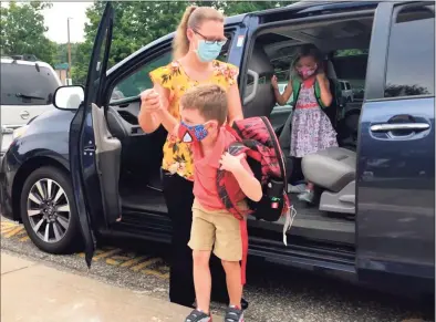  ?? Deborah Rose / Hearst Connecticu­t Media file photo ?? Courtney Kennedy helps her children, twins Owen and Teagan, out of the car for their first day as first-graders at Northville Elementary School in New Milford in September.