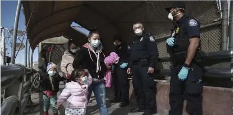  ?? AP FILE; GETTY IMAGES FILE (BELOW) ?? POLITICAL FOOTFALL: A migrant family crosses the border from Ciudad Juarez, Mexico, into El Paso, Texas. Asylum seekers are being let into the United States after waiting for months or years in Mexico. Below, an asylum-seeker embraces a church worker in Brownsvill­e, Texas, after being allowed to cross the border.