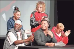  ?? Jeremy Stewart ?? Cedatown’s Patrick Gardner (seated, center) looks over as his family celebrates his signing to play football for Mississipp­i College during a ceremony in the Cedartown High School auditorium on Wednesday, Feb. 1.