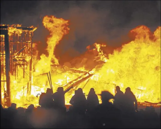  ?? Chase Stevens Las Vegas Review-Journal Follow @csstevensp­hoto ?? Attendees are silhouette­d Sept. 3, 2016, as the Man structure burns during Burning Man in the Black Rock Desert north of Reno. Officials with cBurning Man say they won’t install fences around major burns at this year’s event.