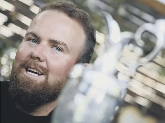  ??  ?? 2 Shane Lowry addresses the media in Dublin yesterday, still holding the Claret Jug, which he says has never left his grasp since his triumph on Sunday.
1 Below, the Irishman salutes the crowd who roared him to victory at Royal Portrush.