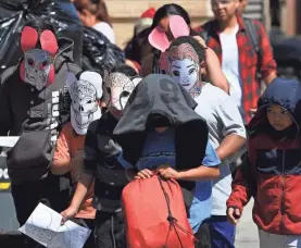  ?? ROBERT DEUTSCH/USA TODAY ?? Children wearing homemade masks to prevent recognitio­n are escorted out of Cayuga Centers in New York in June. The federal government has awarded the nonprofit millions of dollars to place the children in foster care until they can rejoin parents or other relatives.