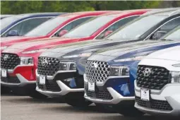  ?? AP PHOTO/DAVID ZALUBOWSKI ?? A line of 2022 Santa Fe SUV’s sits outside a Hyundai dealership in 2021 in Littleton, Colo.