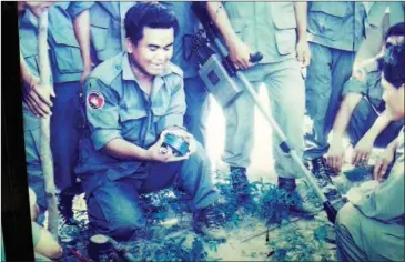  ?? PHAK SEANGLY ?? Aki Ra is seen with a mine removal team in a photograph displayed at his Siem Reap museum.