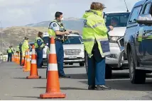  ?? ROSS GIBLIN/STUFF ?? Police stop vehicles heading north on State Highway 1 near Plimmerton on Thursday as part of an Easter crackdown.