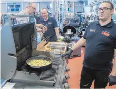 ?? FOTOS: LYDIA SCHÄFER ?? Am Stand von Michael Grossmann (Mitte) kocht Marco Stolze (rechts) „Gnocchi con funghi“im Dutch Oven.