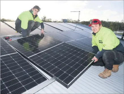  ?? Picture: PAUL CARRACHER ?? SOLAR REVOLUTION: Wades’ Solar tradesmen Mitch Jorgensen and Mitch Seipolt install solar panels on a house.