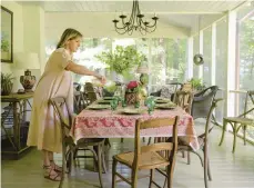  ?? ?? Keith Meacham works in the screen-porch dining room of her mountain home May 12 in Sewanee, Tennessee. Meacham is the co-founder of an oline
business called Reed Smythe & Co. that
sells the kinds of artifacts — sometimes the very things — that decorate the home.