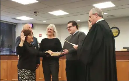  ?? KEITH REYNOLDS — THE MORNING JOURNAL ?? Sharon Sweda takes the oath of office administer­ed by Lorain County Probate Judge James T. Walther on Feb. 13 accompanie­d by her husband, Richard Sweda, Laura Irvin and Corey Shawver, before her first Lorain County commission meeting.