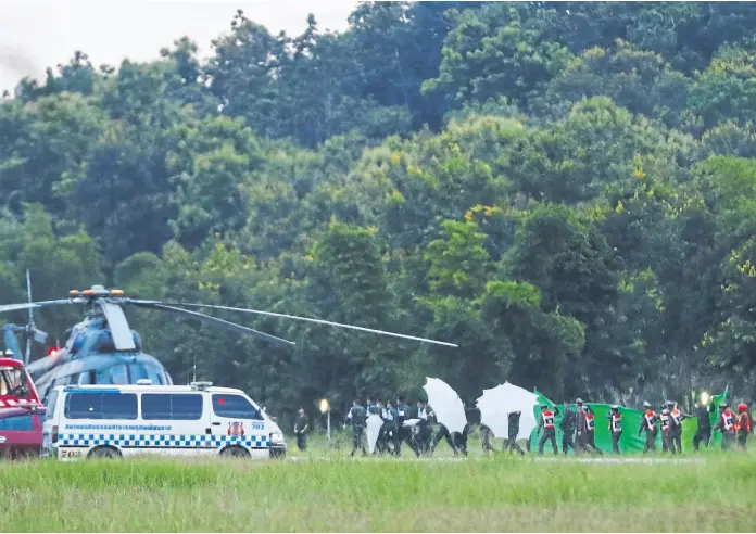  ?? Vincent thian/ap ?? Un equipo de emergencia­s, en el traslado de uno de los chicos rescatados en Tailandia