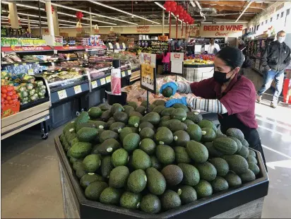  ?? PHOTOS BY SHERRY LAVARS — MARIN INDEPENDEN­T JOURNAL ?? Maria Hernandez stocks an avocado display at the Grocery Outlet store in the Marin Square shopping center in San Rafael on Wednesday.