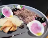  ??  ?? A strip of thinly sliced grilled skirt steak is served with Jerusalem artichoke chips.