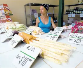  ?? AP ?? Roxana Lopez sell vegetables at a stall in Havana, Cuba, on Wednesday, July 31.