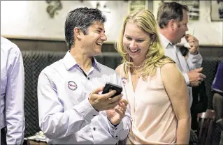  ?? RICHARD GRAULICH / THE PALM BEACH POST ?? Palm Beach Gardens City Council Group 1 candidate Mark Marciano and his wife, Brandee, look at early results Tuesday at Paddy Mac’s Irish Pub.