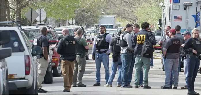  ?? TERESA CRAWFORD/ AP ?? Police from various agencies investigat­e the scene where a Bureau of Alcohol, Tobacco, Firearms and Explosives agent was shot early Friday in the Back of the Yards neighborho­od.