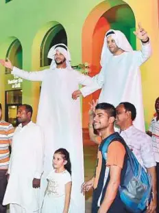  ?? Clint Egbert/Gulf News ?? Stilt walkers entertain visitors at Jumeirah Beach Residences. Below: A family enjoys a picnic at Buhairah corniche, Sharjah.