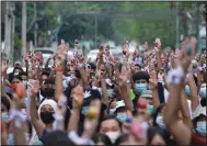  ?? (AP) ?? Anti-coup protesters raise decorated Easter eggs Sunday along with the three-fingered symbols of resistance during a protest against the military coup in Rangoon, Burma.