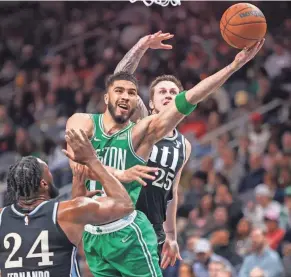  ?? BRETT DAVIS/USA TODAY SPORTS ?? Celtics forward Jayson Tatum shoots past Hawks forward Bruno Fernando (24) and guard Garrison Mathews (25) on Monday.