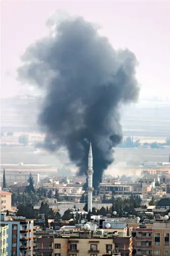  ?? AP ?? Smoke billows from behind a mosque’s minaret in Ras Al-Ain, Syria, during Turkish bombardmen­t on Wednesday.