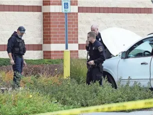  ?? KIRTHMON F. DOZIER/DETROIT FREE PRESS ?? Roseville police look for evidence in front of the Dick’s Sporting Goods at the Macomb Mall where shots were reportedly fired during an altercatio­n Sunday. No injuries were reported, and the unknown gunman had fled.