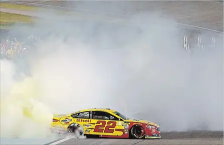  ?? SEAN GARDNER GETTY IMAGES ?? Joey Logano celebrates with a burnout after winning the Monster Energy NASCAR Cup Series Ford EcoBoost 400 and the Cup series championsh­ip.