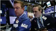  ?? RICHARD DREW — THE ASSOCIATED PRESS ?? Specialist Michael O’Mara, left, and trader Gregory Rowe work on the floor of the New York Stock Exchange, Monday.