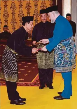  ?? [FOTO BERNAMA] ?? Sultan Muhammad V mengurniak­an Watikah Pelantikan Ketua Pesuruhjay­a SPRM kepada Mohd Shukri di Istana Negara, semalam.