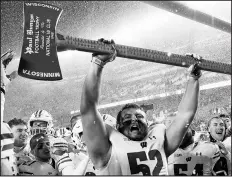  ?? HANNAH FOSLIEN/GETTY IMAGES ?? Wisconson’s David Pfaff hoists the Paul Bunyan Football Trophy after defeating Minnesota.