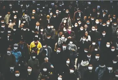  ?? CHARLY TRIBALLEAU/AFP VIA GETTY IMAGES ?? Mask-clad commuters make their way to work during morning rush at the Shinagawa train station in Tokyo.
Japan has been one of the countries hardest hit by the coronaviru­s outbreak.